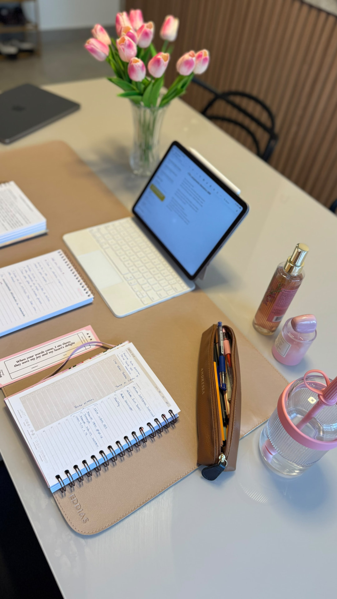 Planner aberto com anotações e tablet na mesa de Andressa